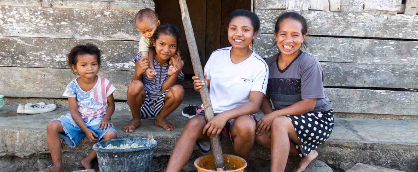 Family in Flores sitting outside their home in their village